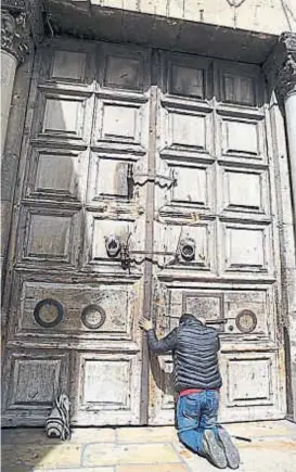  ?? (AP) ?? Puertas cerradas. Un visitante reza ante la Iglesia del Santo Sepulcro.