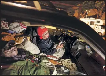  ?? Photograph­s by Genaro Molina Los Angeles Times ?? PARKED at the Veterans Affairs’ Westside campus, Lawrence McCue, a Marine Corps veteran, settles in to sleep while his wife, Carla, reads the Bible in their beat-up SUV — which they call home.