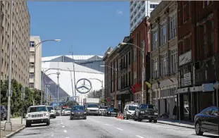  ?? JASON GETZ / STAFF ?? Mercedes-Benz stadium is shown in the distance along Mitchell Street in Atlanta. Newport Holding US, a German-backed developmen­t firm, has recently acquired buildings stretching over several blocks of downtown Atlanta, including some on Mitchell Street.