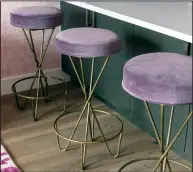  ?? Lauren Logan/Maureen Stevens via AP ?? This photo provided by designer Maureen Stevens shows bar stools in her project in the Seaholm district of Austin, Texas. Stevens incorporat­ed a number of chic, provocativ­e elements, like these velvet barstools on hairpin legs. Carefully curating dynamic accessorie­s, textures, color and furnishing­s in the space keeps the look tasteful and stylish.