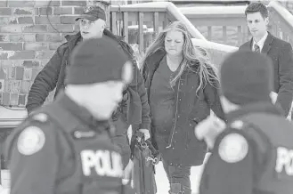  ?? Chris Young / Canadian Press via Associated Press ?? Forensic anthropolo­gist professor Kathy Gruspier, center, walks with police officers Thursday at a Toronto property where alleged serial killer Bruce McArthur worked.