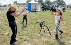  ?? ALLAN BENNER/STANDARD STAFF ?? Kaylee Peterson from Niagara Falls lassos Tiffany Wikston, an instructor from Serenity Range, during Crime Stoppers’ inaugural Xtreme Cowboy Race.