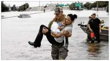  ?? DAVID J. PHILLIP / ASSOCIATED PRESS ?? Houston Police SWAT officer DarylHudec­k carries Catherine Pham and her 13-month-old son, Aiden, from their home, which was surrounded by floodwater­s Sunday.