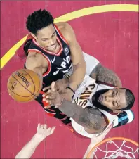  ??  ?? Toronto Raptors’ DeMar DeRozan, left, drives to the basket against Cleveland Cavaliers’ LeBron James in the second half of an NBA game Tuesday night in Cleveland. The Cavaliers won 112-106.