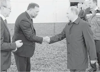  ?? Mikhail Klimentyev / President Press Service files via Associated Press / RIA-Novosti ?? Russian President Vladimir Putin greets metals magnate Oleg Deripaska in September 2014 in Kstovo. President Donald Trump’s former campaign chairman, Paul Manafort, secretly worked for Deripaska to advance the interests of Putin a decade ago.