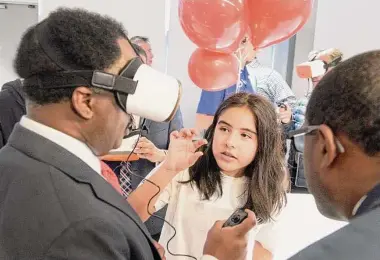 ?? H John Voorhees III/Hearst Connecticu­t Media ?? West Rocks Middle School sixth grader Mia Palacio talks with Lunda Asmani, chief financial officer from the Norwalk Public Schools, about a pair of VR goggles at the Norwalk Public Schools unveiling of its new Verizon Innovative Learning Lab at West Rocks Middle School on Monday morning. It joins Verizon labs at Nathan Hale Middle School and Ponus Ridge STEAM Academy.