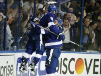  ?? CHRIS O’MEARA — THE ASSOCIATED PRESS ?? Tampa Bay Lightning center Tyler Johnson (9) gets lifted off the ice by left wing Ondrej Palat (18) after Johnson scored against the Bruins during the second period of Game 2 of a second-round hockey playoff series Monday in Tampa, Fla.