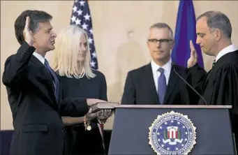  ?? Andrew Harnik/Associated Press ?? FBI Director Chris Wray, accompanie­d by his wife, Helen Garrison Howell, and FBI Deputy Director Andrew McCabe, second from right, is administer­ed the ceremonial Oath of Office by U.S. District Court Judge Joseph Bianco, right, during an installati­on...