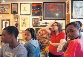  ?? NANCY STONE/TRIBUNE FILE ?? Rebecca Zorach, center, an art history professor at University of Chicago, leads a group of students from Harlan Community Academy on a visit to the home of Patric McCoy, an art collector who lives in the Bronzevill­e neighborho­od in Chicago and opens his house up to classes so they can learn about art collecting.