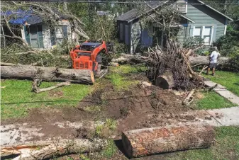  ?? Scott Clause / Lafayette ( La.) Daily Advertiser ?? A resident of Jennings, La., clears trees from houses the day after Hurricane Delta blew through southern Louisiana. Delta is the 25th named storm of the Atlantic hurricane season.