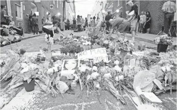  ?? HENRY TAYLOR, USA TODAY ?? People drop off flowers at a memorial in Charlottes­ville, Va., to mourn Saturday’s violence.