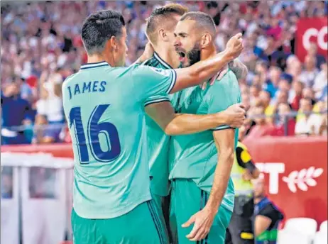 ?? GETTY IMAGES ?? Real Madrid striker Karim Benzema (right) celebrates his goal against Sevilla in their La Liga game at Estadio Ramon Sanchez Pizjuan in Seville on Sunday.