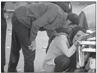  ?? AP/Tasnim News Agency/FARZAD MENATI ?? A woman weeps Monday near the body of a relative who died in Sunday’s earthquake in Sarpol-e-Zahab, Iran.