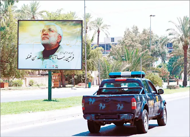  ??  ?? A poster of Abu Mahdi al-Muhandis, deputy commander of Iran-backed militias who was killed in a US drone attack is seen in Baghdad, Iraq on June 26. Iraqi security forces arrested over a dozen men suspected of a spate of rocket
attacks against the US. (AP)