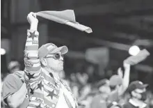  ?? Brett Coomer / Staff photograph­er ?? An Astros fan waves his rally towel during Friday’s game at a raucous Minute Maid Park.