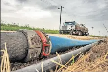  ?? [THE OKLAHOMAN ARCHIVES] ?? A temporary line used to move water to an oil production site runs along a roadway in Kingfisher County in July. Operators use temporary lines to get water to well locations to cut down on costs and to reduce truck traffic issues.