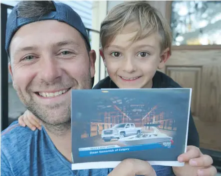  ?? JIM WELLS ?? Dean Semeniuk and his five-year-old son Kaden show off a photograph of the truck and boat they won in a Calgary Stampede lottery. “It feels amazing. I’ve just got a perma-smile,” said Semeniuk.