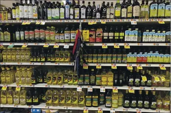  ?? PHOTOS BY KATIE WORKMAN — THE ASSOCIATED PRESS ?? A variety of olive oils are displayed at a grocery store in New Milford, Conn., on March 12. There is a lot of confusion about which olives oils to buy and how to use them.