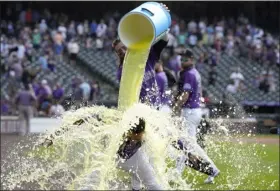  ?? ANDY CROSS — THE DENVER POST ?? Rockies’ outfielder Charlie Blackmon, back, douses Elias Diaz, who drove in the winning run the ninth inning Wednesday at Coors Field.