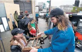  ?? KENNETH K. LAM/BALTIMORE SUN ?? Residents evicted from the Bell Foundry on North Calvert Street are helped by supporters to remove their belongings from the building condemned by city officials.