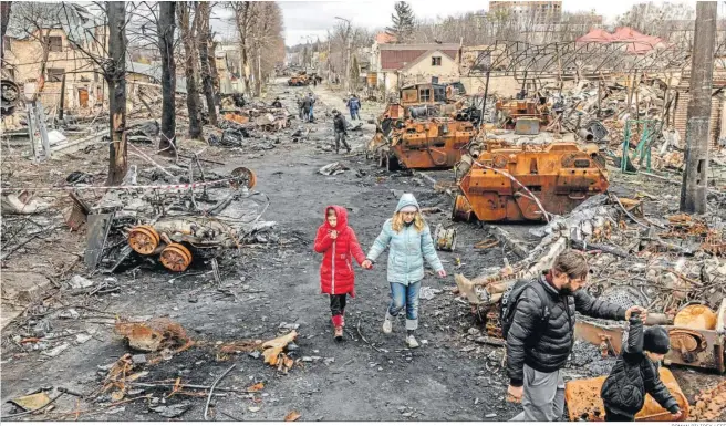  ?? ROMAN PILIPEY / EFE ?? Una familia camina entre la destrucció­n en la localidad de Bucha.