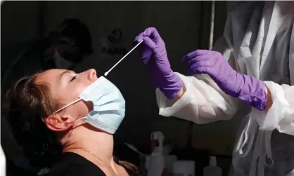  ?? Photograph: Gonzalo Fuentes/Reuters ?? A health worker prepares to administer a nasal swab to a patient at a coronaviru­s testing site.