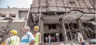  ?? Agence France-presse ?? ↑ Egyptians walk outside the National Cancer Institute in Cairo on Monday.