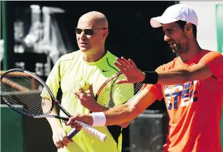  ?? CHRISTOPHE SIMON/AFP/GETTY IMAGES ?? Novak Djokovic, right, talks with his new coach Andre Agassi at a training session ahead of the 2017 French Tennis Open on Friday in Paris. Djokovic has been in a slump.