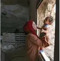  ??  ?? The wife of Ahmed Amarneh holds her daughter at their home built in cave.