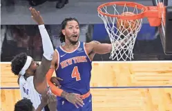  ?? PHELAN M. EBENHACK/AP ?? Knicks guard Derrick Rose (4) shoots next to Magic guard Terrence Ross, left, during the first half Wednesday in Orlando, Fla.