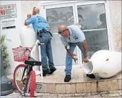  ?? Joe Raedle Getty Images By Karen Kaplan ?? MOSQUITO CONTROL inspectors in Miami look for standing water, where the insects breed.