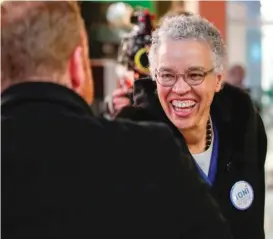  ?? KAMIL KRZACZYNSK­I/AFP/GETTY IMAGES ?? Toni Preckwinkl­e greets a commuter on Tuesday during a campaign stop at the Thompson Center.