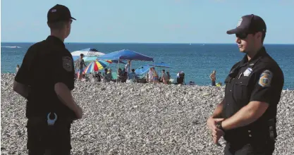  ?? STAFF PHOTOS BY MATT WEST ?? FAMILY PLANNING: Scituate police Chief Mike Stewart, right, shows pictures on his smartphone of rowdy crowds at Humarock Beach in years past. Yesterday, the annual July 3 celebratio­n was brought to a close, with police on hand, above, to clear the...