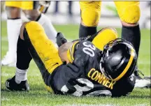  ?? AP PHOTO ?? Pittsburgh Steelers running back James Conner (30) is injured after being tackled by Los Angeles Chargers defensive back Adrian Phillips in the second half of an NFL football game, Sunday, in Pittsburgh.