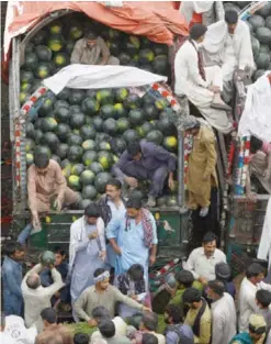  ??  ?? LAHORE: Pakistani farmers and traders gather as they sell watermelon­s at a fruit market in Lahore yesterday. — AFP