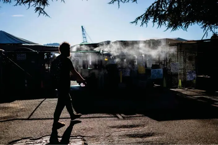  ?? Photograph: Mathieu Lewis-Rolland/Reuters ?? A man enters an encampment that has been outfitted with a misting station during a heatwave in Portland, Oregon, in August 2021.