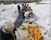  ?? ?? Kari Cummins, front, joins other volunteers as they sort food in the parking lot of The Church of Latter-day Saints in Lake Arrowhead on Monday.