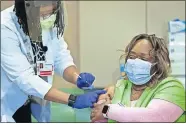  ?? SERVICE] ?? Nurse clinician Vicki Johnson gives ER nurse Tracy Everett her second COVID-19 vaccine Jan. 7 at Stroger Hospital in Chicago. [JOSE M. OSORIO/CHICAGO TRIBUNE VIA TRIBUNE NEWS