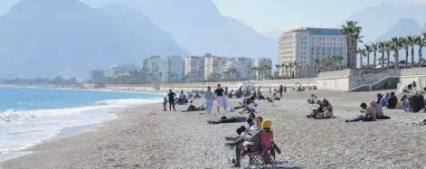  ??  ?? People are seen on a beach in the southern province of Antalya, Turkey, Feb. 22, 2021.