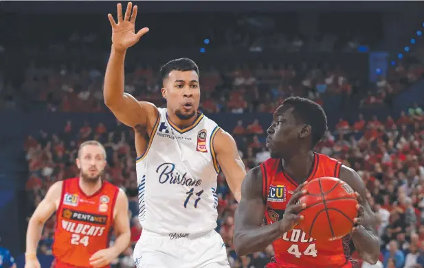  ??  ?? TAKING CHANCES: Sunday Dech of the Wildcats looks to pass the ball against Stephen Holt of the Bullets in their round five NBL match. Picture: GETTY IMAGES