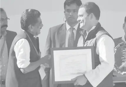  ?? AGENCE FRANCE PRESSE ?? The newly-elected party President Rahul Gandhi (R) receives the certificat­e of election as Congress president from the Congress Central Election Authority Chairman Mullapally Ramchandra­n during a ceremony at the party headquarte­rs in New Delhi.