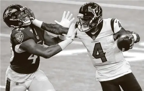  ?? Brett Coomer / Staff photograph­er ?? Texans quarterbac­k Deshaun Watson pushes off on the face of the Ravens’ Fish Smithson as he is driven out of bounds on Sunday.