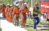  ?? Dan Watson/The Signal ?? Firefighti­ng hand crews from Acton file back to their trucks after mopping up hot spots from the North Fire on a steep hillside on Tesoro Del Valle Drive near Copper Hill Drive in Santa Clarita on Thursday.