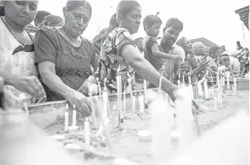  ??  ?? Christian devotees light candles as they pray at a barricade near St. Anthony’s Shrine in Colombo a week after a series of bomb blasts targeting churches and luxury hotels on Easter Sunday in Sri Lanka. — AFP photo