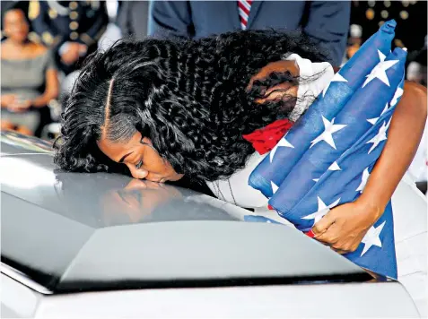  ??  ?? Myeshia Johnson, wife of Sergeant La David Johnson, above right, kisses his coffin during Saturday’s service in Hollywood, Florida