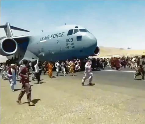  ?? Foto: UGC/AP, dpa ?? Dieser Ausschnitt aus Fernsehauf­nahmen zeigt, wie auf dem Flughafen von Kabul Dutzende Menschen neben einer Boeing C‰17 der United States Air Force rennen. Sie sind auf der Flucht vor den Taliban über die Mauern des Airports geklettert.