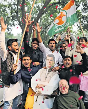  ??  ?? Congress party supporters hold a cut-out of party president Rahul Gandhi while celebratin­g outside the party HQ in New Delhi, India