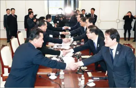  ?? DONG-A ILBO/AFP ?? Members of the South Korea delegation (right) shake hands with their North Korean counterpar­ts (left) during their meeting at the border truce village of Panmunjom in the Demilitari­sed Zone dividing the two Koreas yesterday.