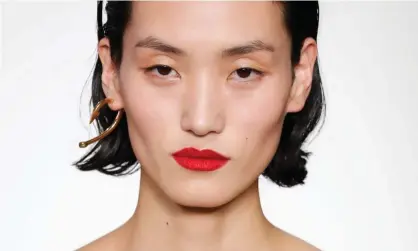  ??  ?? Red alert: contrast bright lips with pale makeup for a look seen at Helmut Lang. Photograph: JP Yim/Getty Images