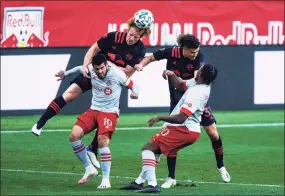  ?? Eduardo Munoz Alvarez / Associated Press ?? New York Red Bulls defenders Tim Parker and Aaron Long fight for the ball against Toronto FC midfielder Alejandro Pozuelo and attacker Ayo Akinola on Sunday in Harrison, N.J.